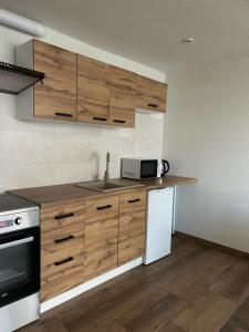 a kitchen with wooden cabinets and a white refrigerator at Domki caloroczne Hotel Zagiel in Niewiesze