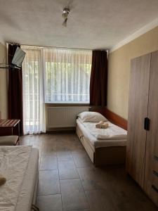 a bedroom with two beds and a window at Domki caloroczne Hotel Zagiel in Niewiesze