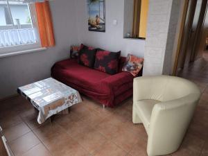 a living room with a red couch and a white chair at Ferienhaus B1 Concordiasee in Friedrichsaue