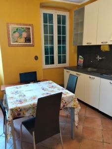 a kitchen with a table with chairs and a tablecloth on it at Appartamento Ortensia in Montale