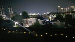 a view of a city at night with lights at 핑크하우스옥상바베큐파티 in Daejeon