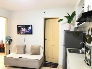 a kitchen with a couch and a tv on the wall at MJ Luxury Living in Iloilo City