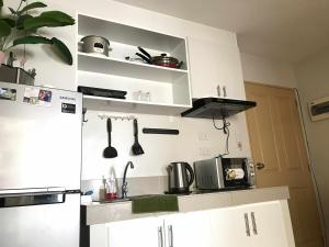 a kitchen with white cabinets and a refrigerator at MJ Luxury Living in Iloilo City