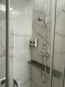 a bathroom with a shower with a glass door at Areias do Norte in Póvoa de Varzim +8 photos