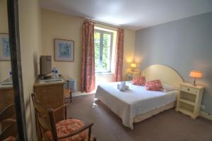 a bedroom with a bed and a window at Logis Hôtel Le Moulin de la Beune in Les Eyzies-de-Tayac
