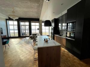 a kitchen with black cabinets and a living room at Tamula Lake View Apartment in Võru