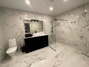a white bathroom with a toilet and a sink at Tamula Lake View Apartment in Võru +7 photos