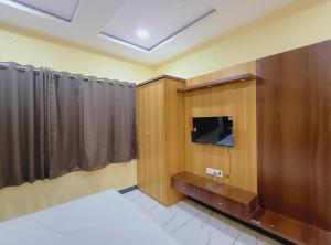 a room with a bed and a flat screen tv at Hotel Shree Raghunandan Palace in Ujjain +86 photos
