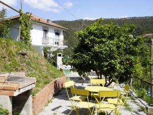 a patio with yellow chairs and a table and a tree at Villa Maremonti - con 3 piscine in Sestri Levante