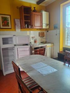 a kitchen with a table and a kitchen with white appliances at Appartamento Oleandro in Montale