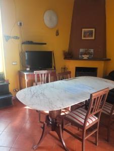 a large marble table in a living room with chairs at Appartamento Oleandro in Montale