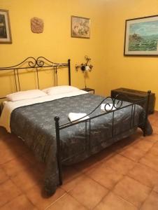 a black bed in a room with yellow walls at Appartamento Oleandro in Montale