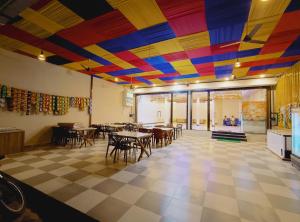a restaurant with a colorful ceiling with tables and chairs at Hotel Shree Raghunandan Palace in Ujjain