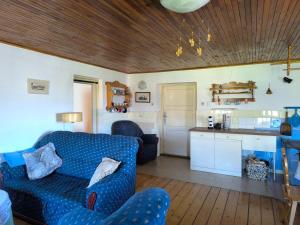 a living room with a blue couch and a kitchen at Rodinná chalupa in Zdíkov