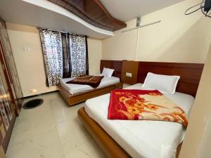 a bedroom with two beds and two windows at Nilgiris Stayz - Home Stay at Ooty in Ooty