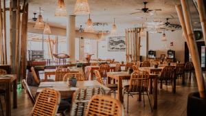 a dining room with tables and chairs and chandeliers at Hotel Tarifa Lances, a member of Radisson Individuals in Tarifa