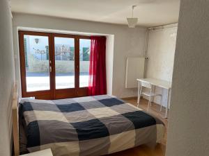 a bedroom with a bed and a desk and a window at La cameretta in Mont-sur-Rolle