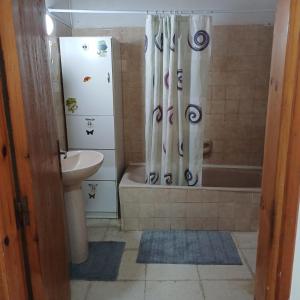 a bathroom with a shower curtain and a sink at Vocation Rest House in Anogyra in Anoyira