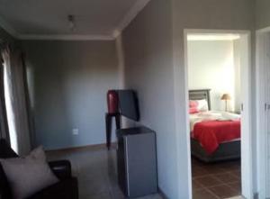 a bedroom with a bed and a television in it at The Seige Guesthouse in Pretoria +29 photos
