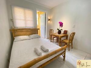 a bedroom with a bed and a table with chairs at Nol's Inn in Iloilo City