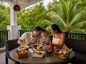 a family sitting at a table eating food at Sundaras Infinity Jungle Resort & Spa in Dambulla +40 photos
