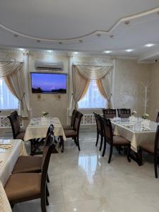 a dining room with tables and chairs and a flat screen tv at Готель-ресторан Октан in Holovanivs'k