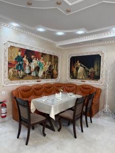 a dining room with a table and chairs and paintings at Готель-ресторан Октан in Holovanivs'k