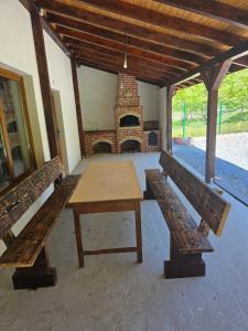 a patio with two benches and a table and a fireplace at Casa Tudor - Râul Mare Retezat in Clopotiva