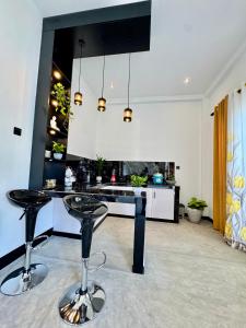 a kitchen with two bar stools in front of a counter at Villa Lithu in Weligama +27 photos