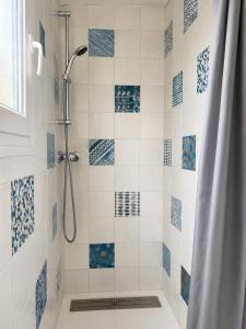 a bathroom with a shower with blue and white tiles at Camping de la Baie-Baie de Somme-Sites et Paysages in Pendé +51 photos