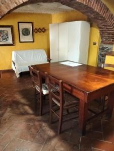a dining room with a table and a bed at Appartamento Gelsomino in Montale