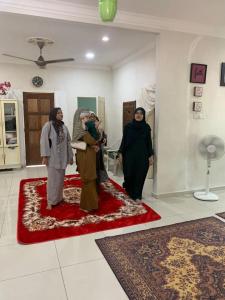 a group of three women standing in a room at Homestay kampung dusun in Balik Pulau