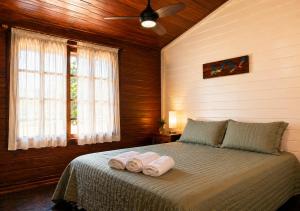 a bedroom with a bed with two towels on it at Sopro do Vento Roots Hotel in Analândia