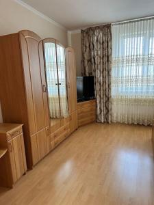 a living room with a tv and a large window at Садиба Villa Bella in Velyatyn