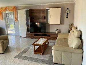 ein Wohnzimmer mit Sofa, Fernseher und Tisch in der Unterkunft Ferienwohnung Balkon oder Terrasse in Kall