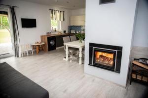 a living room with a fireplace and a table at Domki letniskowe Malina 1 in Gawrony