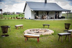 a fire pit in a yard with chairs and a building at Domki letniskowe Malina 1 in Gawrony