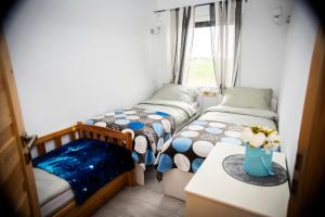 two twin beds in a room with a window at Domki letniskowe Malina 1 in Gawrony +19 photos