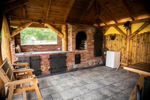 a kitchen with a brick wall and a refrigerator at Domki letniskowe Malina 1 in Gawrony