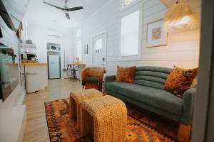 a living room with a green couch and a kitchen at The Frida Tiny House-Hot Tub-Pet Friendly-No Pet Fee! in Albuquerque