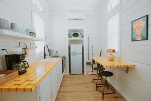 a kitchen with white walls and a counter with a table at The Frida Tiny House-Hot Tub-Pet Friendly-No Pet Fee! in Albuquerque +13 photos