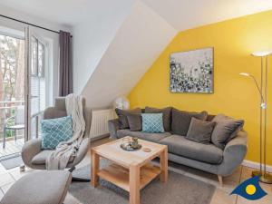 a living room with a couch and a table at Fraeulein Loddin Whg_ Ole in Kölpinsee