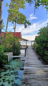 a wooden walkway leading to a resort on the beach at Raja Ampat Blue Sea in Besir