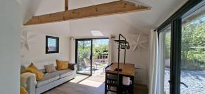 a living room with a couch and a sliding glass door at Cabane Cozy & Calme in Janville
