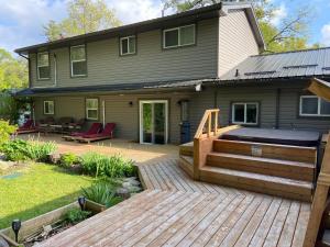 a home with a deck and a house at Romantic Studio Cottage in Lambton Shores