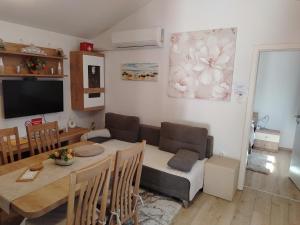 a living room with a table and a dining room at Apartmani Bernarda in Poreč