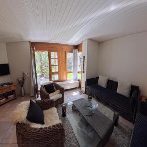 a living room with a couch and a table at Wellness apartment with pool and terrace in Lenzerheide