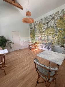 a room with tables and chairs and a mural of palm trees at La Maison d'Amboise in Amboise