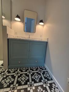 a bathroom with a blue cabinet and a mirror at La Maison d'Amboise in Amboise