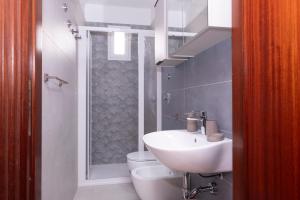 a bathroom with a sink and a toilet and a shower at Appartamento Noa in San Vito lo Capo